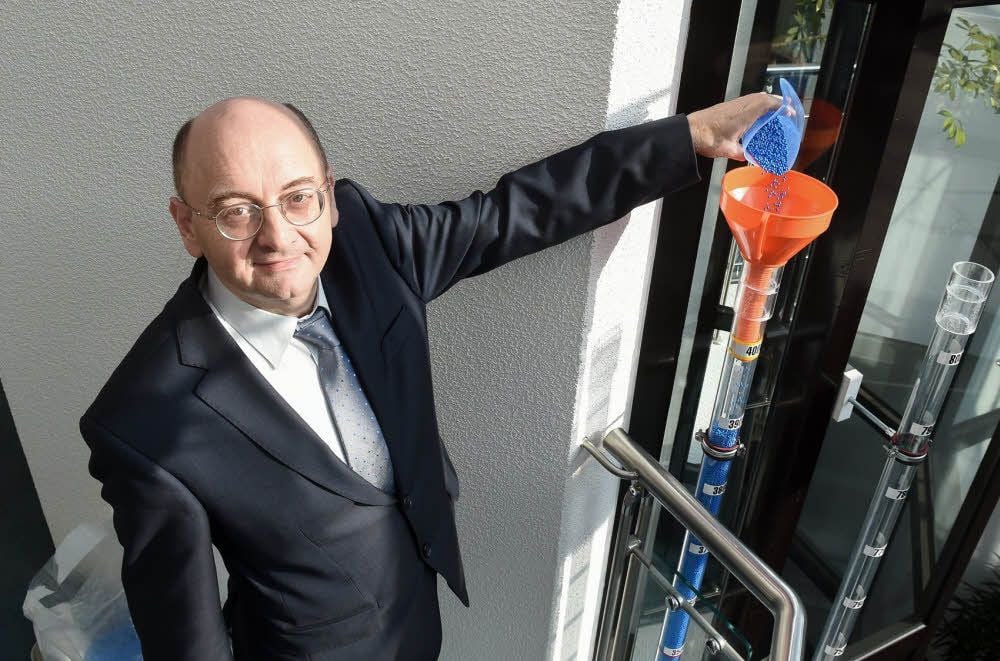 Sparkassenvorstandsvorsitzender Markus Klatte schüttet blaues Granulat für 1.000 Euro in die Röhre.