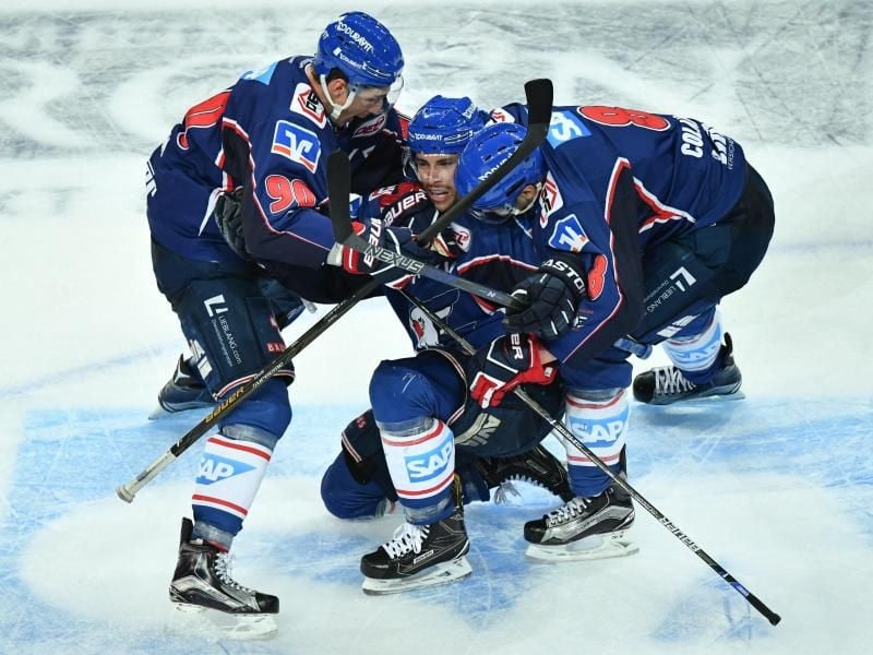Mannheims Torschütze Matthias Plachta (M) jubelt mit Luke Adam (l) und Carlo Colaiacovo über einen weiteren Treffer gegen die Eisbären Berlin. Foto: Uwe Anspach