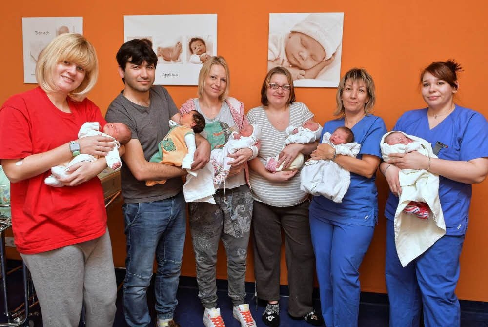 Stolz halten Mütter, Väter und Hebammen die Neugeborenen im Arm. Von links nach rechts: Carolin Kasper mit Ellie, Vater Yusuf mit Lyana, Anika Reich mit Bella, Antje Müller mit Emilia, die Hebammen Kathrin und Theresa mit Minna Luise und Emely Sophie.