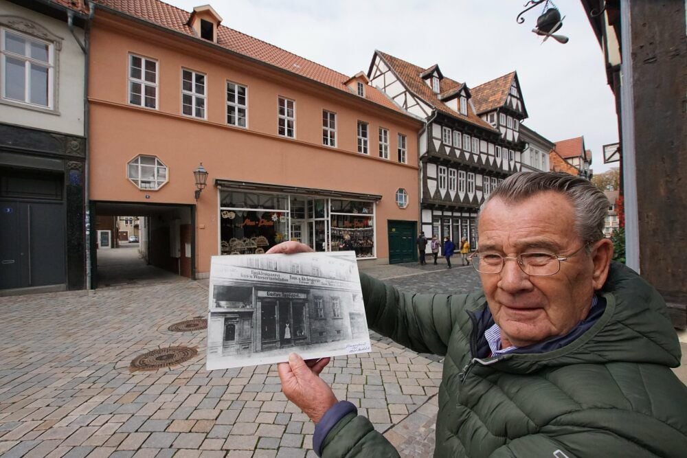 Günter Spröggel, der am Donnerstag 85 Jahre alt wird, zeigt vor dem heutigen Haus eine alte Fotografie des früheren Firmensitzes des Familienunternehmens in der Marktstraße 4.