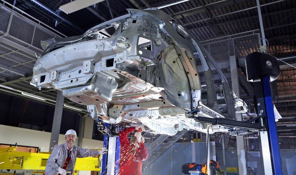 Porsche-Mitarbeiter arbeiten an der Rohkarosse eines Macan. Der Testbetrieb zum Bau des kleinen Geländewagens ist angelaufen.