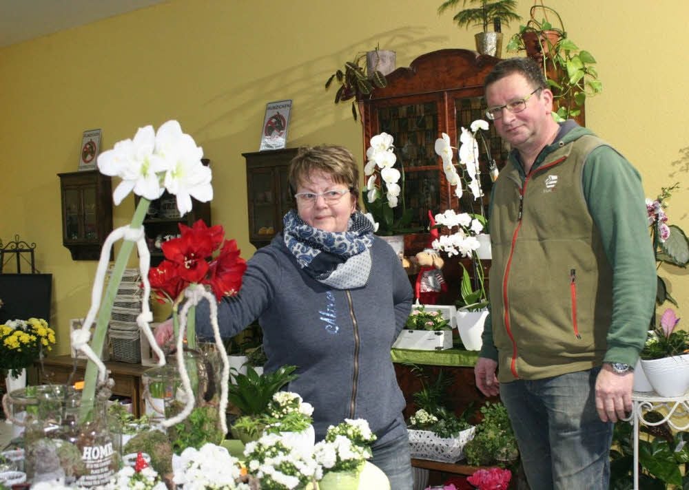 Umgeben von Orchideen (im Hintergrund) und Amaryllis (vorn) präsentieren sich hier Floristin Karin Schindler und Gärtner und Geschäftsinhaber Axel Schwert im „Blumengarten Vier Jahreszeiten“ am Jessener Höfchen.