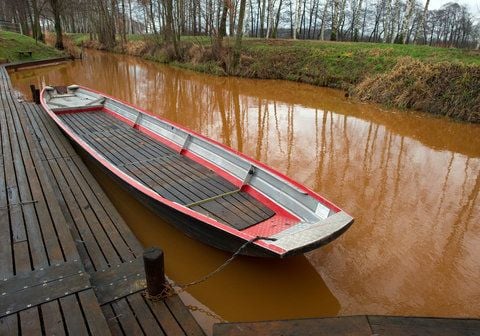 Bräunlich-Rot ist das Wasser eines Fließes am Naturspreewaldhafen in Ragow nahe Lübben (Brandenburg) gefärbt. Nach dem Ende vieler Lausitzer Braunkohletagebaue macht ansteigendes Grundwasser Mensch und Natur zu schaffen. (FOTO: DPA)