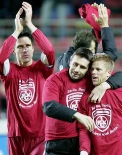Die Kaiserslauterer Aleksander Knavs, Nenad Bjelica und Markus Anfang (von links) freuen sich nach Spielschluss am Dienstagabend (04.03.2003) über ihren Sieg und haben T-Shirts angezogen, auf denen sie ihre Freude über das kommende Pokalfinale bekunden. Mit einem 3:0 Sieg über Werder Bremen qualifizierte sich der 1. FC Kaiserslautern im Fritz Walter-Stadion für das DFB-Pokalfinale in Berlin am 31.05.2003. (Foto: dpa)