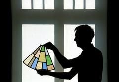 Im Museum im brandenburgischen Eisenhüttenstadt befestigt am Mittwoch (17.08.2005) der Kurator der Ausstellung «Kirche in der ersten sozialistischen Stadt Deutschlands», Axel Drieschner, ein Teil eines Rundfensters der evangelischen Kirchenbaracke von Stalinstadt (heute Eisenhüttenstadt) aus dem Jahr 1954 vor einem Fenster des Museums. (Foto: dpa)