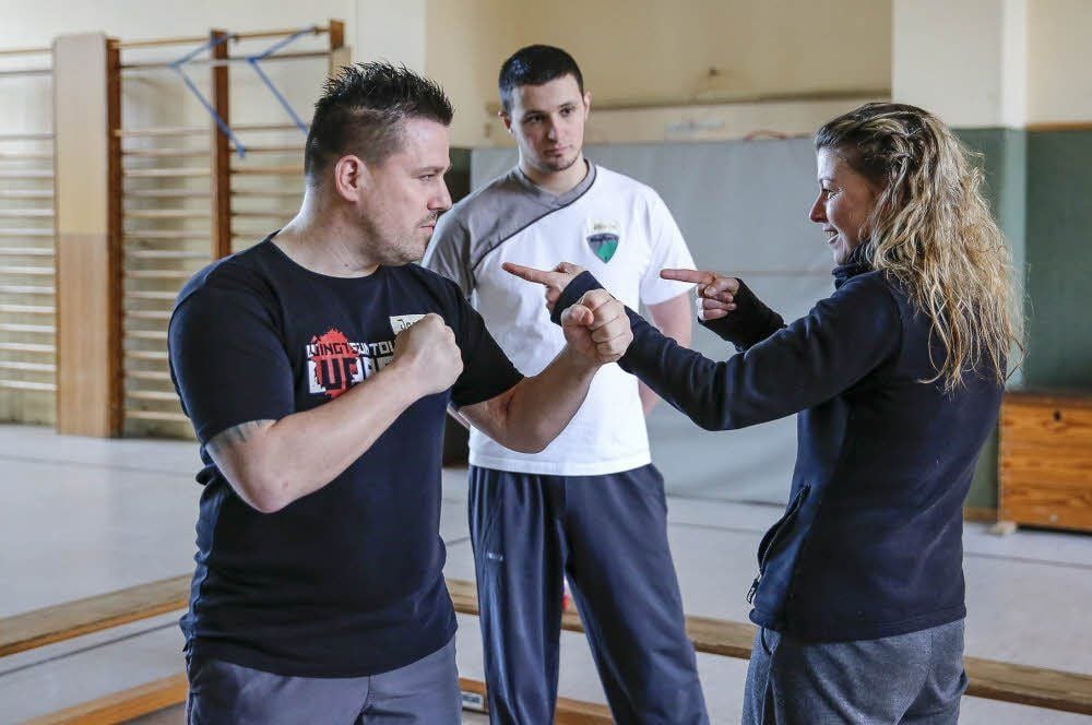 Jens Nerling (l.) erklärt Ines Schütz aus Zeitz die Grundlagen der Selbstverteidigung, Kevin Klawonn schaut zu.