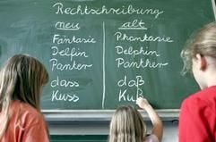 Kinder einer Frankfurter Grundschule schreiben die jeweils neuen und alten Schreibweisen von Wörtern an eine Tafel. (Archivfoto: dpa)