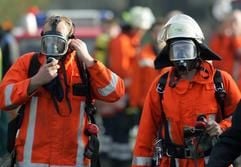 Feuerwehrleute mit Atemschutzmasken kommen am Dienstag (08.11.2005) in Rhadereistedt bei Zeven (Landkreis Rotenburg) aus der Biogasanlage. (Foto: dpa)