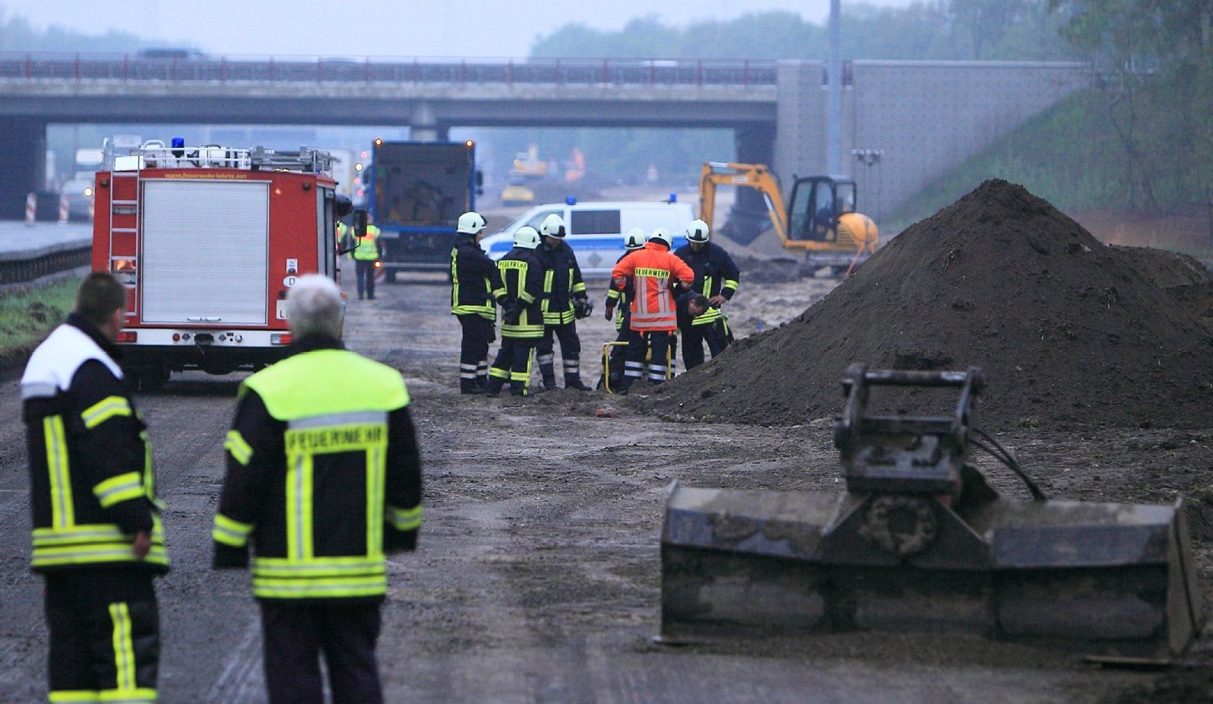 Mitarbeiter der Feuerwehr stehen an der Schnittstelle der Autobahnen A2 und A7 am Kreuz Hannover (Niedersachsen).