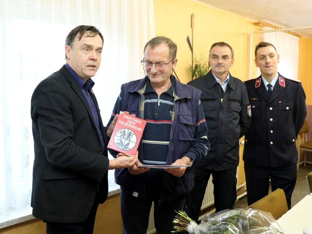 Harald Stahn erhält nach der Übergabe der Urkunde aus den Händen von Jessens Bürgermeister Michael Jahn (links) das Schild, das den Betrieb als „Partner der Feuerwehr“ kennzeichnet. Erste Gratulanten sind Hans-Peter Schaefer und Torsten Winkelbauer (rechts).