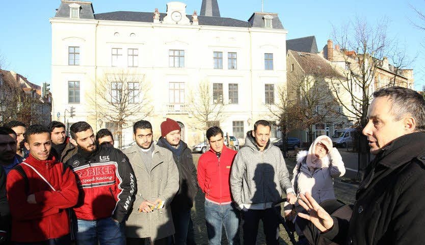 Hochschul-Mitarbeiter Kristian Tourneau (rechts) führte knapp 30 angehende Studenten, allesamt Flüchtlinge, durch Bernburg.