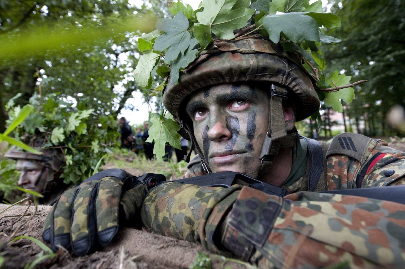 Ein getarnter Soldat auf dem Gelände eines Truppenübungsplatzes der Bundeswehr.