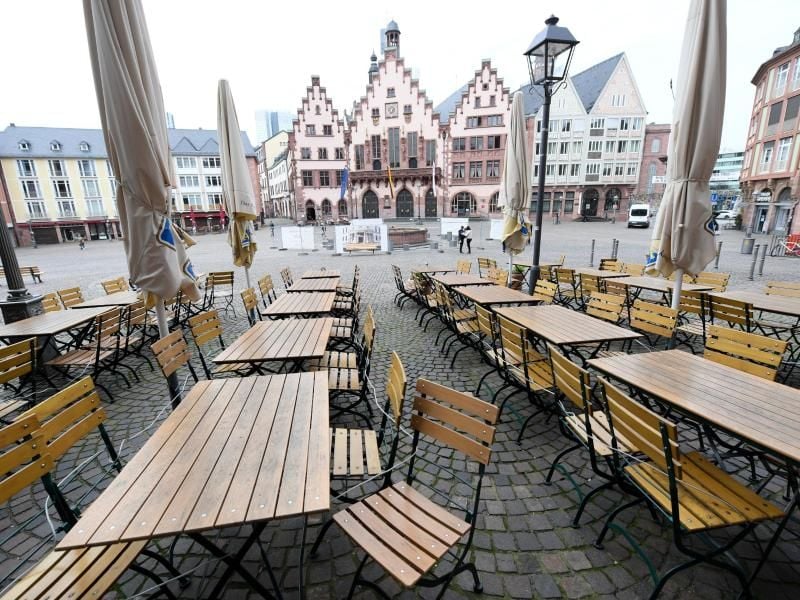 Leere Tische und Stühle stehen vor einer Gaststätte auf dem Frankfurter Römerberg. Foto: Arne Dedert/dpa/Archivbild
