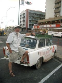 Rolf Becker aus Halle steht auf einem Parkplatz in der Innenstadt von Windhuk (Namibia) vor seinem mit Werbung plakatierten und bis obenhin mit «Ossi-Produkten» beladenen Trabant (Foto: dpa)