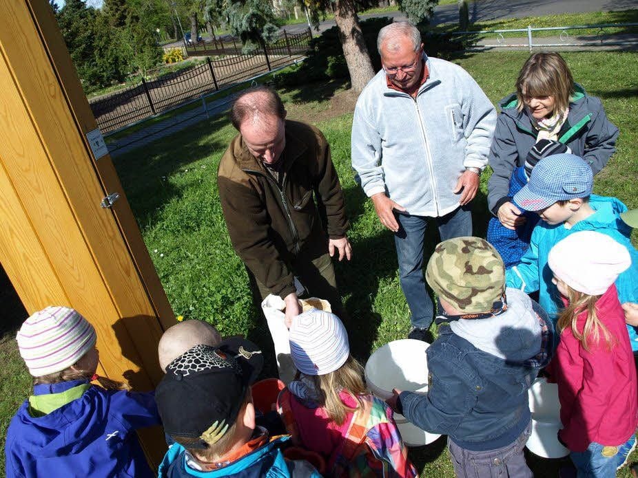 Axel Mitzka vom Naturpark Dübener Heide verteilt die Samen an die Kindergartenkinder.