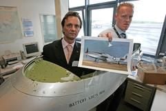 Stefan Bergmann von der Bezirksregierung Münster, und Marcus Müller (r.), von der Luftaufsicht des FMO, präsentieren am Donnerstag (18.05.2006) in der Luftaufsicht des Flughafens Münster-Osnabrück (FMO) in Greven (Kreis Steinfurt) ein Cockpit-Teil eines Flugzeugs vom Typ North American P-51 Mustang. (Foto: dpa)
