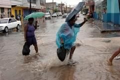 Das hätte schlimmer kommen können: Passanten gehen in Kingston auf der Insel Jamaika über die überflutete Straße. (Foto: dpa)