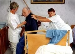 Zwei Krankenschwestern versorgen einen an Alzheimer erkrankten Mann bei einem Hausbesuch. (Archivfoto: dpa)