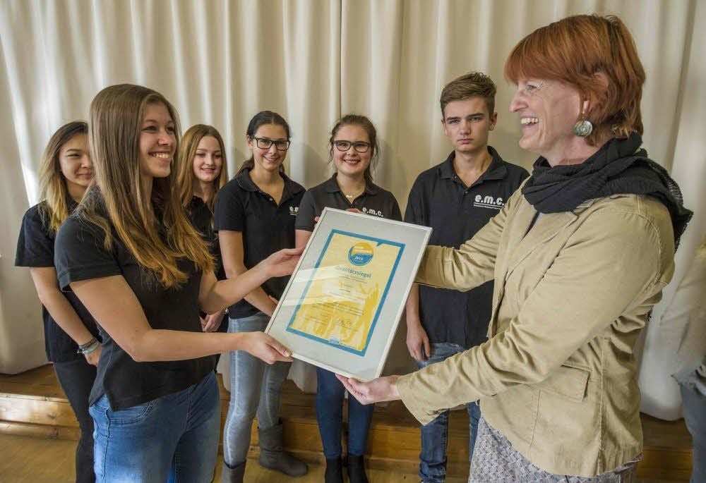 Jessy-Belle Heinze (links) nimmt für die Schülerfirma „e.m.c.“ des Ballenstedter Wolterstorff-Gymnasiums die Auszeichnung mit dem Qualitätssiegel des Fachnetzwerkes Schülerfirmen durch Susanne Pilz (rechts) entgegen.