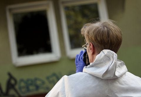 Ein Kriminaltechniker fotografiert in Dortmund vor einem Wohnhaus den Tatort. (FOTO: DPA)