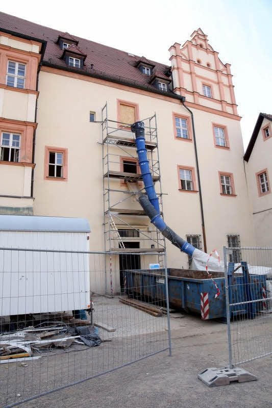 Eine Schuttrutsche führt von der zweiten Etage in einen Container auf dem Hof von Schloss Bernburg.