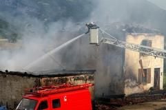 Ein Feuermann kämpft gegen die Flammen an der Scheune der Reitschule in Frankreich. (Foto: dpa)