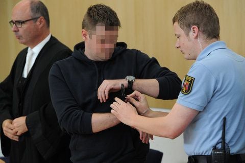 Dem wegen Mordes angeklagten Stefan M. (Mitte) werdenin einem Gerichtssaal des Landgerichts in Trier von einem Justizbeamten die Handschellen abgekommen. (FOTO: DAPD)
