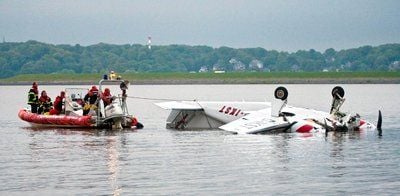 Feuerwehrleute bergen ein Sportflugzeug aus der Elbe bei Hamburg. (FOTO: DPA)