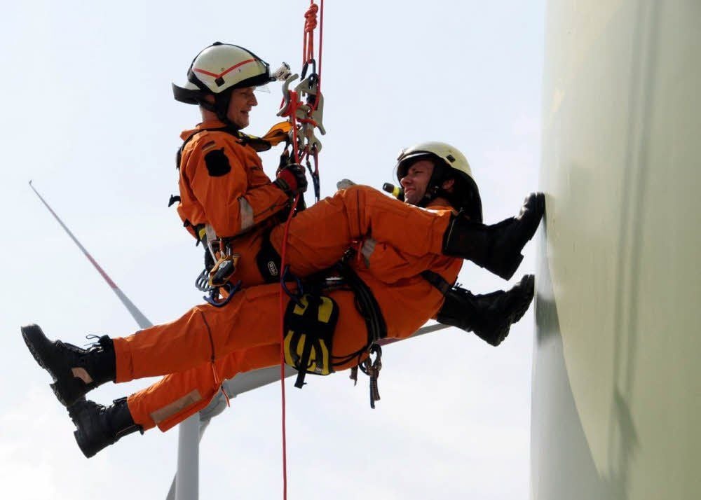 Ingo Künne, Leiter der Höhenrettung der Feuerwehr Coswig, seilt den „verletzten Monteur“, seinen Feuerwehrkameraden Steffen Schubert, an der Außenwand des Windradturmes aus 100 Metern Höhe ab.