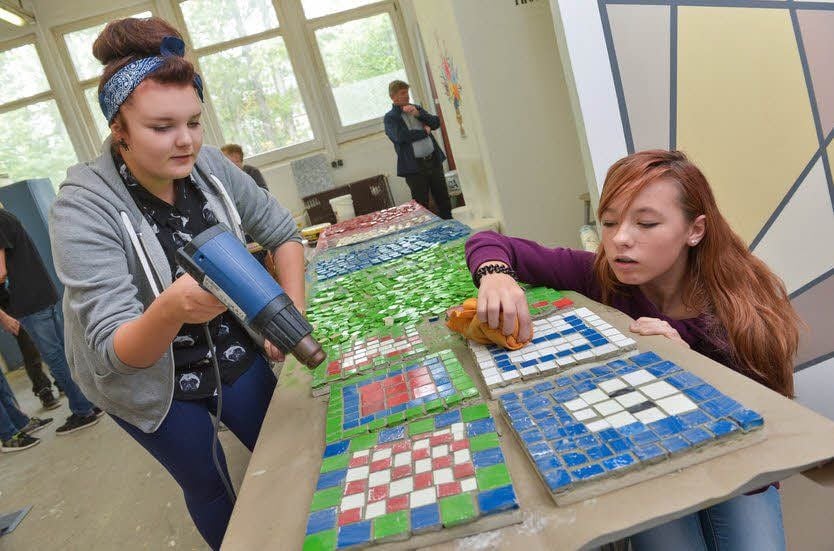Die Schüler fügen auch kleine Fliesen zu Mosaiken zusammen.