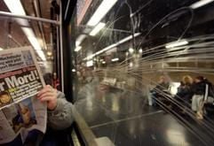 Ein Mann liest am Freitag in einer U-Bahn mit zerkratzten Fensterscheiben in Düsseldorf Zeitung (Archivfoto vom 07.11.2003) . "Scratching" heißt das Phänomen, mit dem vor allem Verkehrsbetriebe zunehmend zu kämpfen haben. Mit Nägeln, Schlüsseln, Schraubenziehern oder Industriediamanten ritzen Jugendliche ihre Namenskürzel oder andere Zeichen in Scheiben ein. (Foto: dpa)