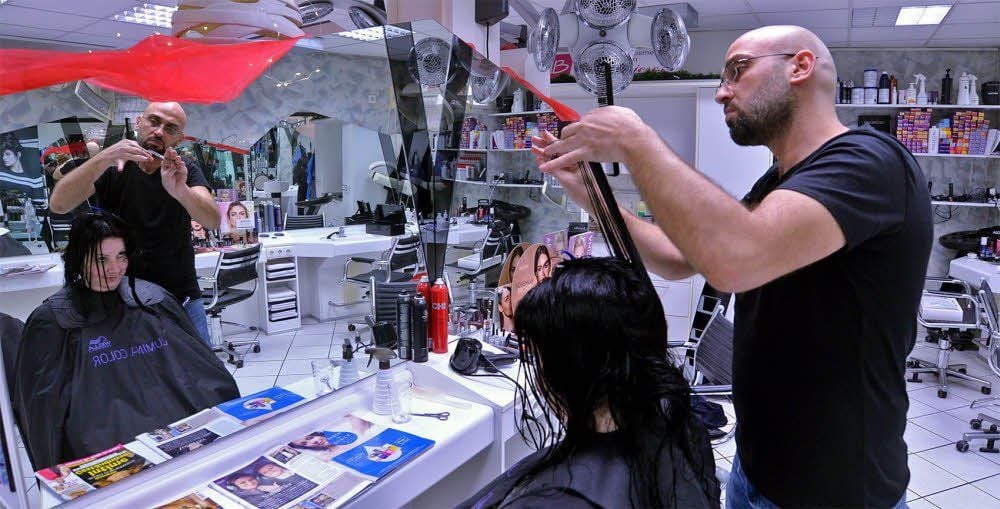 Die Kunden des Friseursalons am Tie reagieren positiv auf den syrischen Praktikanten und frischen ihre Englischkenntnisse bei ihm auf.