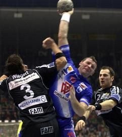 Michail Jakimovic (Portland San Antonio Pamplona) wirft am Sonntag (02.03.2003) beim Champions-League-Spiel in der Magdeburger Bördelandhalle auf das Tor des SC Magdeburg. Bennet Wiegert (l) und Stefan Kloppe versuchen ihn abzuwehren. Der derzeit formschwache Handball-Bundesligist verlor das Viertelfinal-Hinspiel in eigener Halle gegen Portland San Antonio mit 22:26 (9:12). Das Rückspiel findet am Samstag (08.03.2003) in Pamplona statt. (Foto: dpa)
