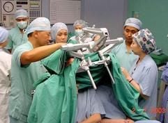 Ärzte des Raffles Hospital in Singapur, links Neuro-Chirurg Keith Goh (mit erhobenen Arm), bereiten die siamesischen Zwillinge auf die Operation vor. Die Mediziner verzichten auf ihr Honorar, während die Klinik alle übrigen Kosten übernimmt. (Foto: dpa)