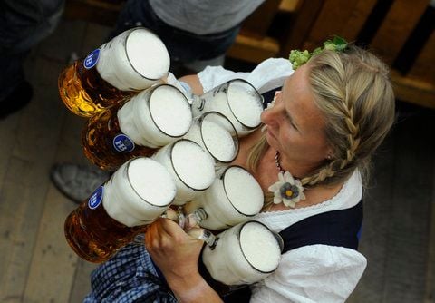 Eine Kellnerin trägt in einem Festzelt auf dem Oktoberfest in München Maßkrüge zu den Gästen. (FOTO: DPA)