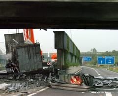 An der Autobahnausfahrt Braunschweig Nord Richtung Berlin liegt am Freitag (16.07.2004) ein durch einen Lastwagenunfall zerquetschter Fahrbahnteiler neben demolierten Leitplanken auf der Straße. Der ausgebrannte LKW steht neben einer beschädigten Lärmschutzwand. Durch die Flammen wurde die über die Autobahn führende Brücke so schwer beschädigt, dass sie vorerst mehrere Tage weder über- noch unterfahren werden kann. Das bedeutet Verkehrsengpässe in der Region in Fahrtrichtung Norden und Osten. Der Schaden wird auf mehrere Millionen Euro geschätzt. Die beiden LKW-Insassen wurden durch den Brand der beiden Fahrzeug-Dieseltanks schwer verletzt. (Foto: dpa)