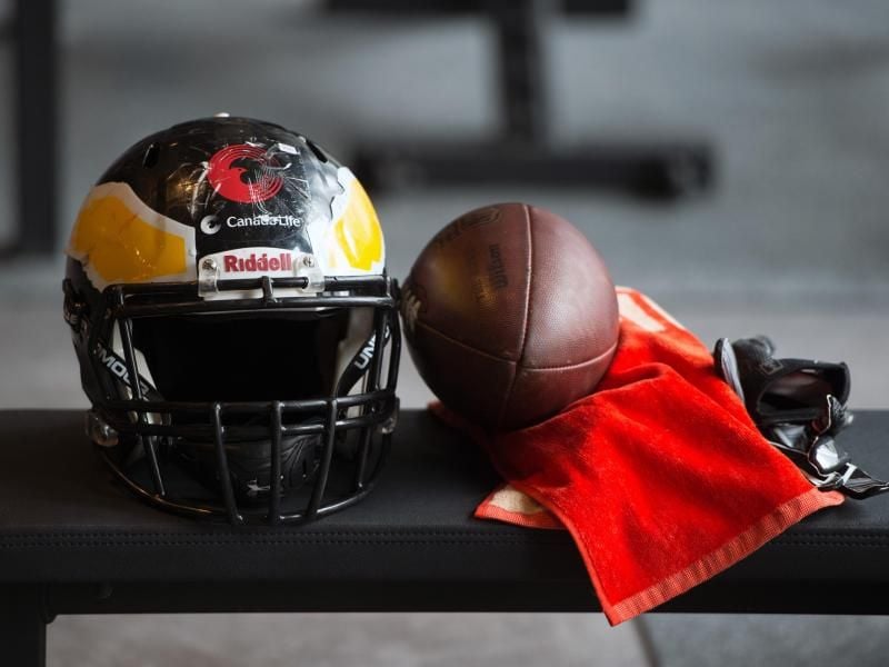 Ein Helm, ein Handtuch und ein Football liegen auf einer Trainingsbank. Foto: Soeren Stache/Archiv