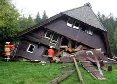 Zwei Feuerwehrmänner stehen am Sonntag (1. Oktober) vor einem schwer beschädigten Freizeitheim bei St.Georgen (Schwarzwald-Baar-Kreis).