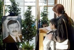 Eine Frau und ein Kind stehen am Freitag (03.06.2003) vor einem Portät des früheren FDP-Politikers Jürgen Möllemann in der Kapelle des Zentralfriedhofs in Münster. (Foto: dpa)