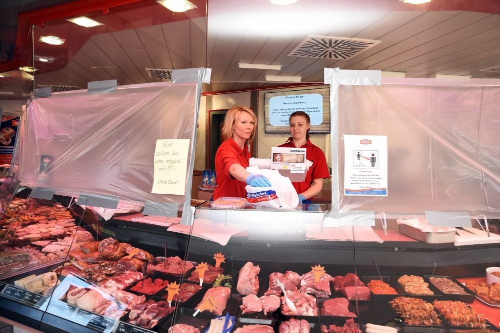 Stephanie Dubetz (li.) und Ines Schröder verkaufen in der Filiale Merziener Straße der Köthener Fleisch und Wurstwaren hinter einer Folienschutzwand.