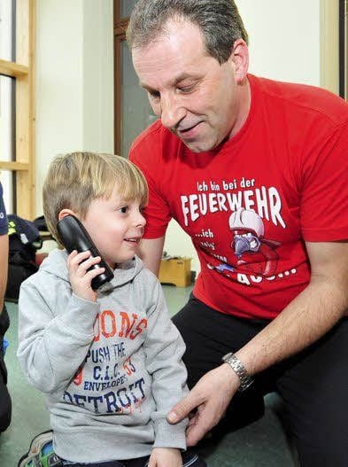 Feuerwehrmann Falko Bertram zeigt dem vierjährigen Leon, was zu tun ist, wenn es brennt. Gemeinsam wählen sie den Notruf.