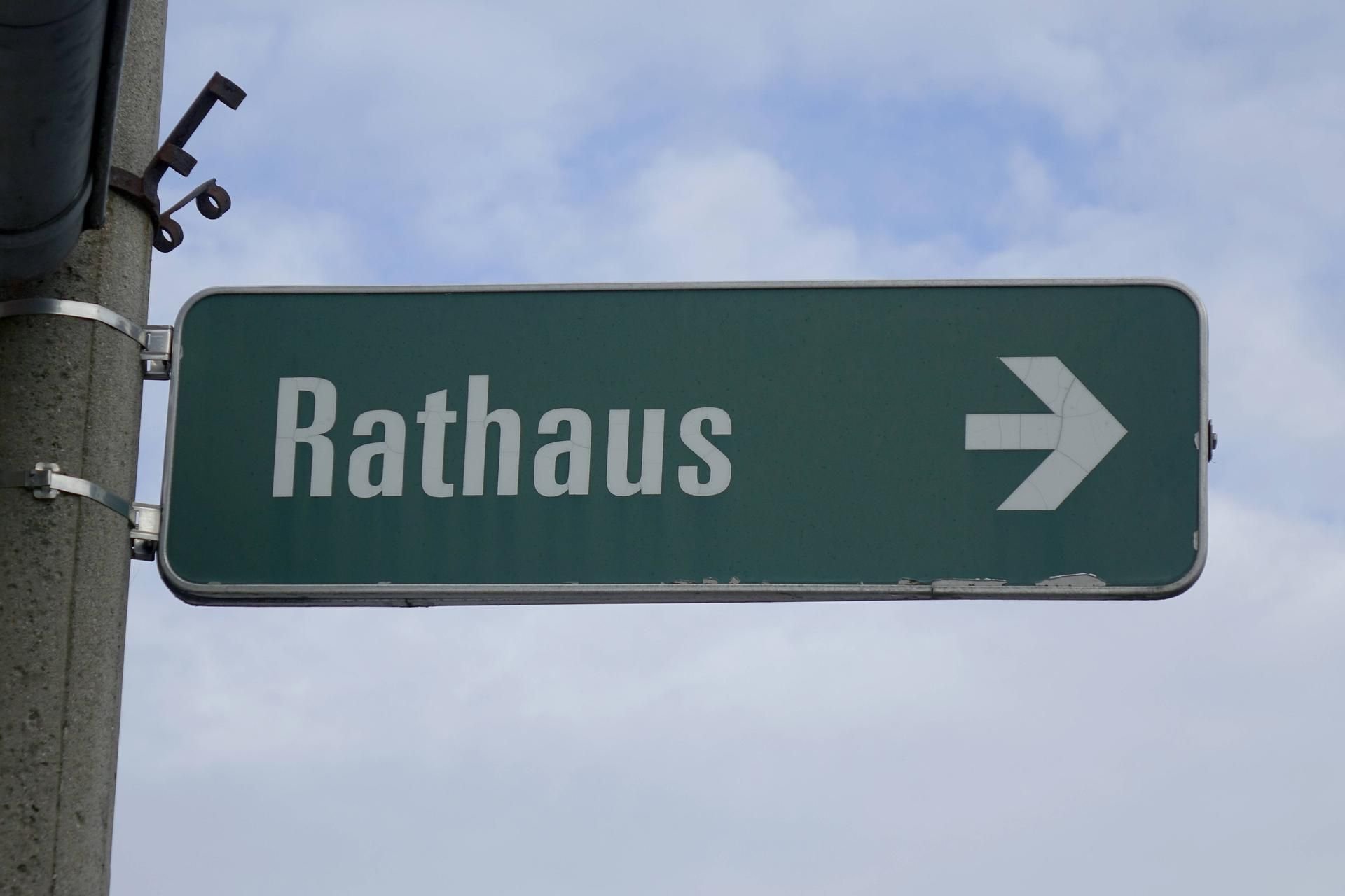 Ein Wegweiserschild zum Rathaus.