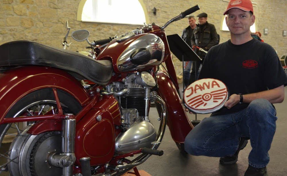 Jörg Bechtel mit seiner 500er Jawa und einer extra gebackenen Torte in der Hand.