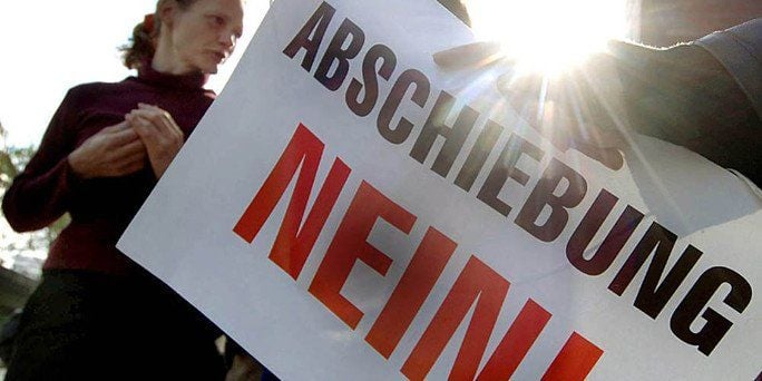 Vertreter von Flüchtlingsorganisationen mit einem Plakat «Abschiebung Nein!»