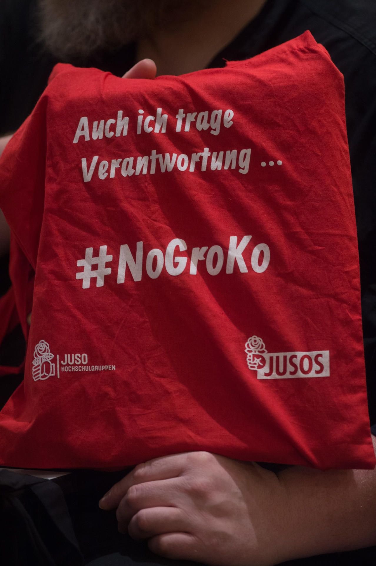 Ein Delegierter des SPD-Landesparteitages zeigt in Wernigerode seinen Stoffbeutel mit der Aufschrift „Auch ich trage Verantwortung“ und „#NoGroKo“.