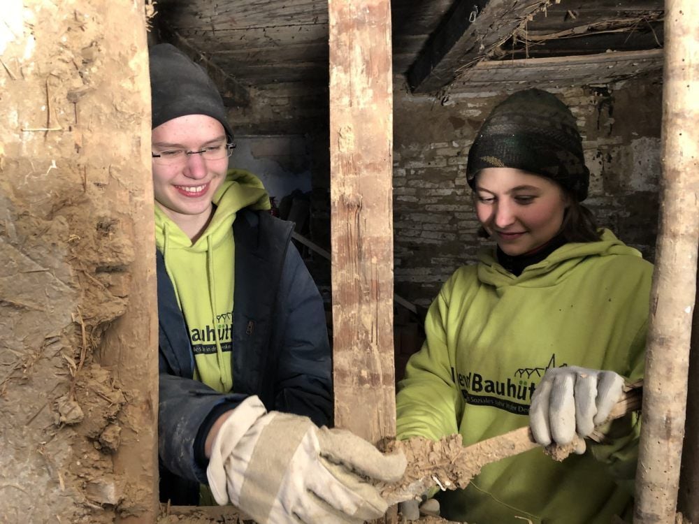 Charlotte Riemer und Miriam Koehler entfernen das Füllmaterial zwischen den Fachwerkhölzern.