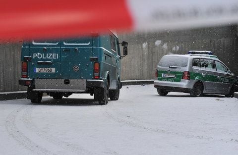 Zwei Polizeiwagen stehen am 14.01.2013 in Berlin in einer Zufahrt zu einer Tiefgarage im Stadtteil Steglitz. Von dort aus haben bislang unbekannte Täter einen Tunnel zu einem Tresorraum einer Bank gegraben. Mit ihrer Beute konnten die Räuber unerkannt fliehen. (FOTO: DPA)