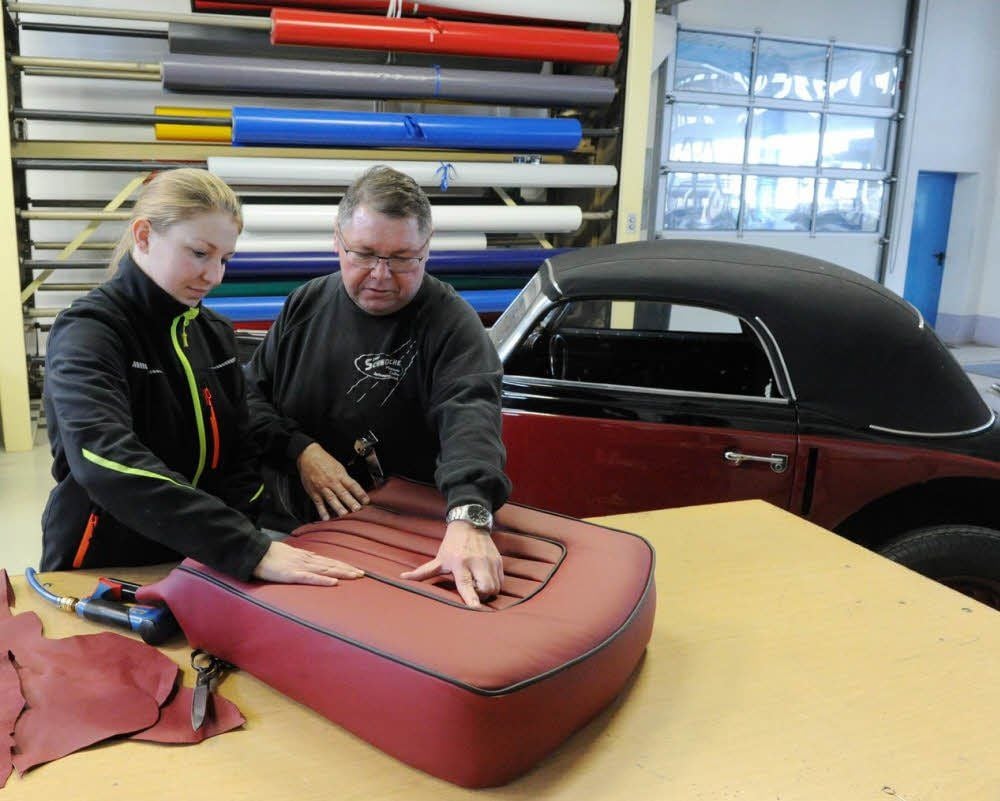Carolin Hotze bespricht mit Meister Jens Schwoche die Arbeit an einem Oldtimer-Autositz.