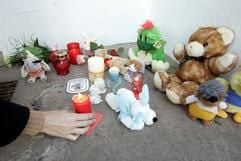 Ein Frau stellt am Freitag (15.12.2006) in Sömmerda (Thüringen) eine Kerze vor einem Hauseingang ab. Ein zehn Monate altes Baby ist hier in der Wohnung seiner Mutter verdurstet. (Foto: dpa)