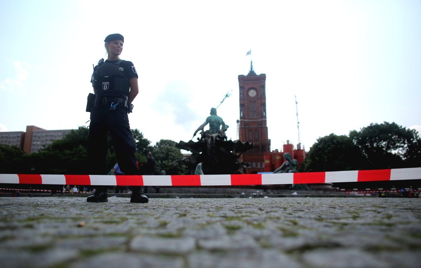 Eine Polizeibeamtin sichert den Tatort am Neptunbrunnen vor dem Roten Rathaus in Berlin.